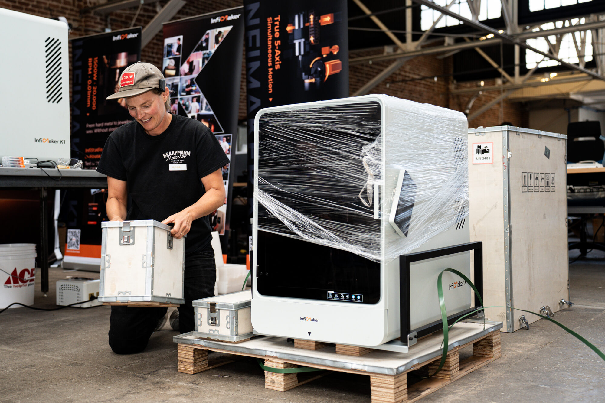 Unwrapping an InfiMaker machine at the booth